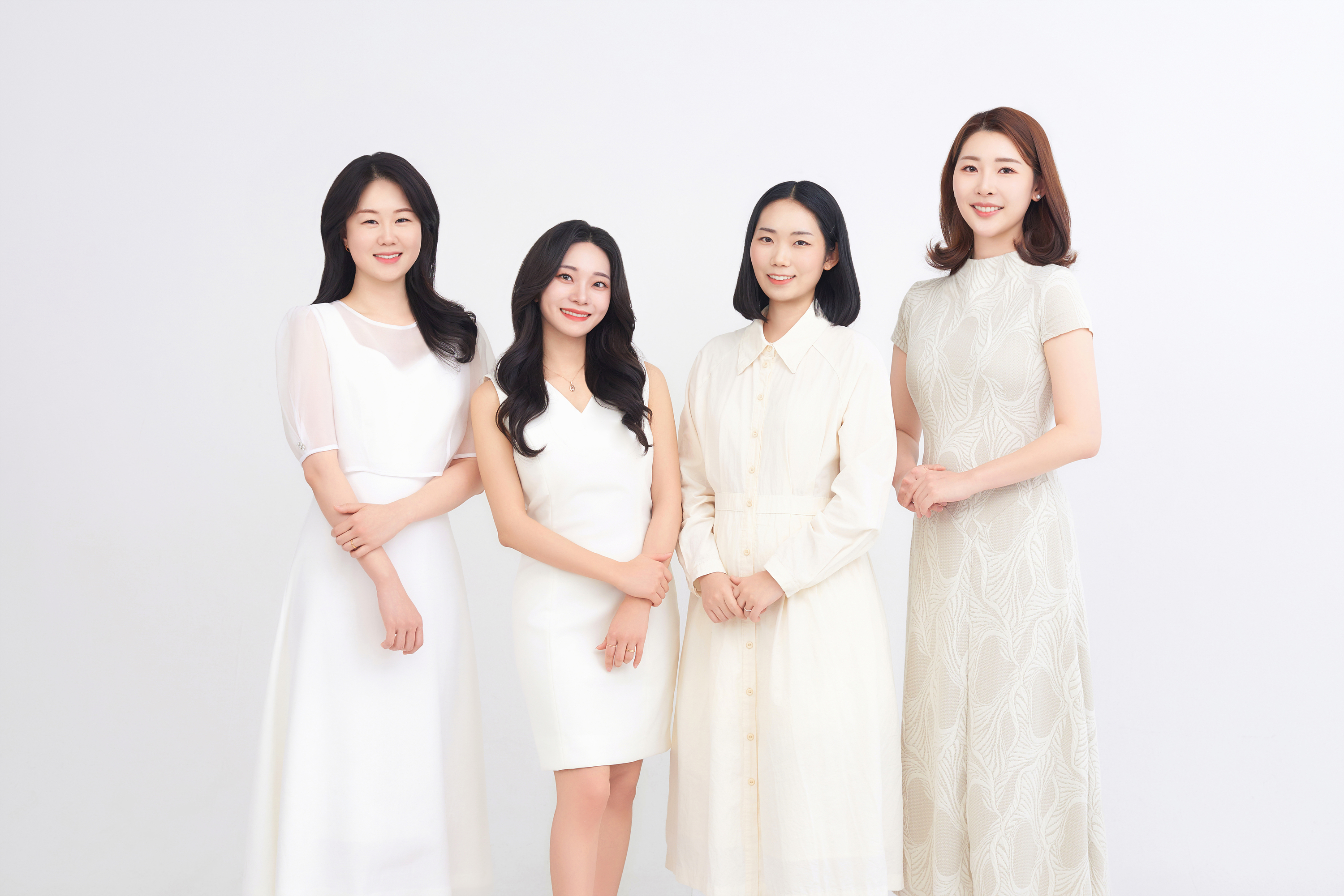 흰 의상을 입고 서 있는 리블링스 멤버 네 명